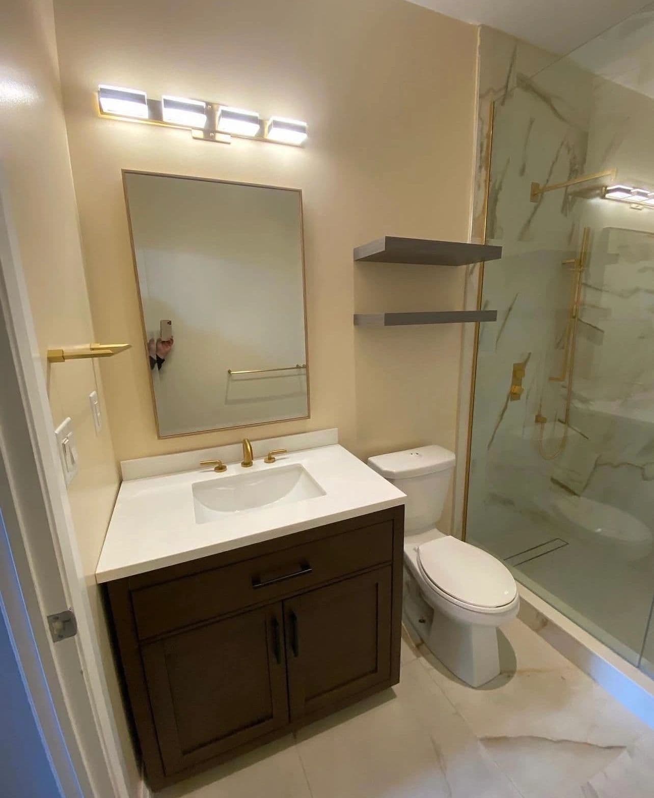 The Elvis — dark vanity bathroom renovation with gold fixtures